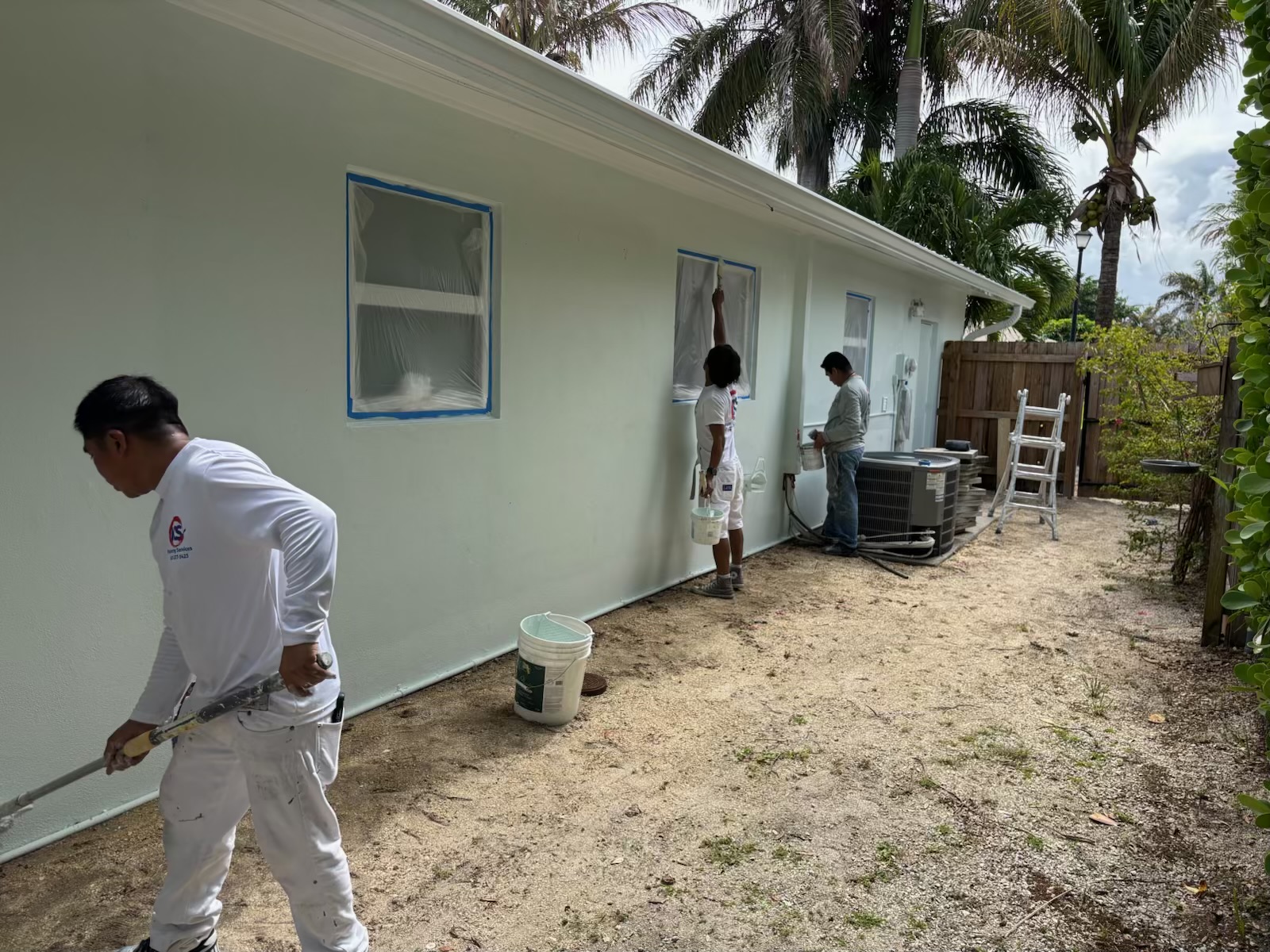 Painting crew working on an exterior side wall